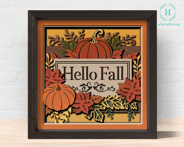 Decorative sign with pumpkins and leaves saying 'Hello Fall' in a black frame.