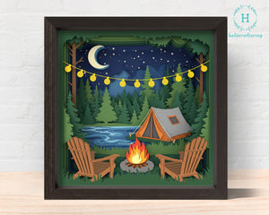 Framed artwork of a camping scene with a tent, fire pit, and chairs under a starry night sky. 3D camping tent Shadow box Svg 